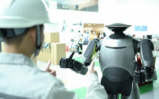 在广汽研究院,人形机器人团队的周仁义在演示GoMate机器人互动功能(新华社记者 邓华 摄)